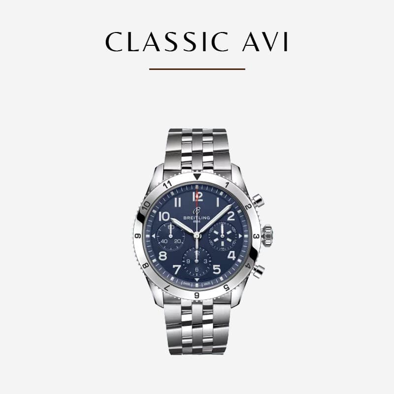 Eine Breitling-Uhr Classic AVI aus Edelstahl mit blauem Zifferblatt und drei Hilfszifferblättern. Die Uhr verfügt über ein silbernes Gliederarmband und ein Datumsfenster. Der Text „CLASSIC AVI“ ist elegant über der Uhr auf einem hellen Hintergrund dargestellt.