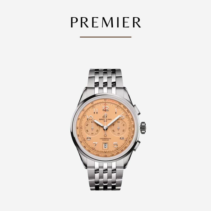 Eine luxuriöse Breitling-Uhr mit silbernem Metallarmband und lachsfarbenem Zifferblatt mit dem Wort „PREMIER“ in der Mitte. Die Uhr verfügt über drei Hilfszifferblätter, eine Datumsanzeige und mehrere kleine Markierungen in einem minimalistischen, eleganten Design. Der Markenname auf dem Zifferblatt lautet „Breitling“.