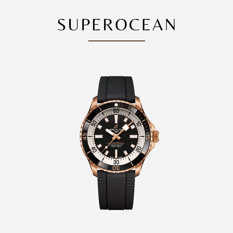 Eine Breitling Superocean-Uhr mit schwarzem Zifferblatt und Roségold-Lünette, mit leuchtenden Stundenmarkierungen, einer Datumsanzeige bei drei Uhr und einem schwarzen Gummiarmband auf weißem Hintergrund. Das Wort „Superocean“ steht über der eleganten Breitling-Uhr.
