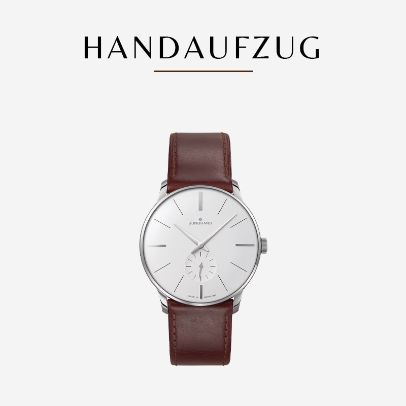 Eine Armbanduhr aus der Junghans Meister Kollektion mit weißem Zifferblatt, silbernem Gehäuse und braunem Lederarmband ist auf weißem Hintergrund abgebildet. Oben steht in schwarzer Schrift „Handaufzug“. Die Uhr verfügt über silberne Stundenmarkierungen und ein kleines Hilfszifferblatt bei 6 Uhr.