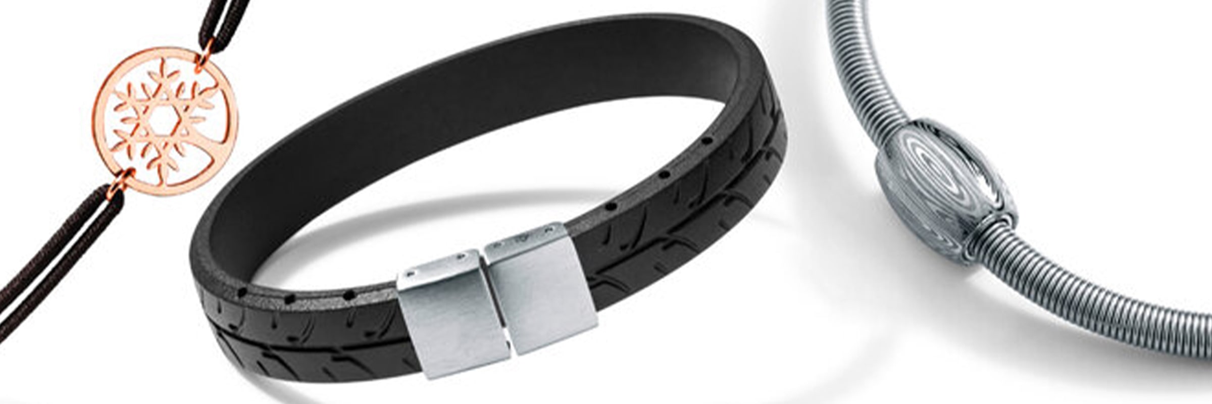 Es werden drei Armbänder gezeigt: ein schwarzes Lederarmband mit Metallverschluss, ein rundes Silberarmband mit eingraviertem zylindrischen Anhänger und ein schwarzes Kordelarmband mit einem dekorativen runden Anhänger aus Roségold. Jedes Armband hat ein einzigartiges Design und Material.