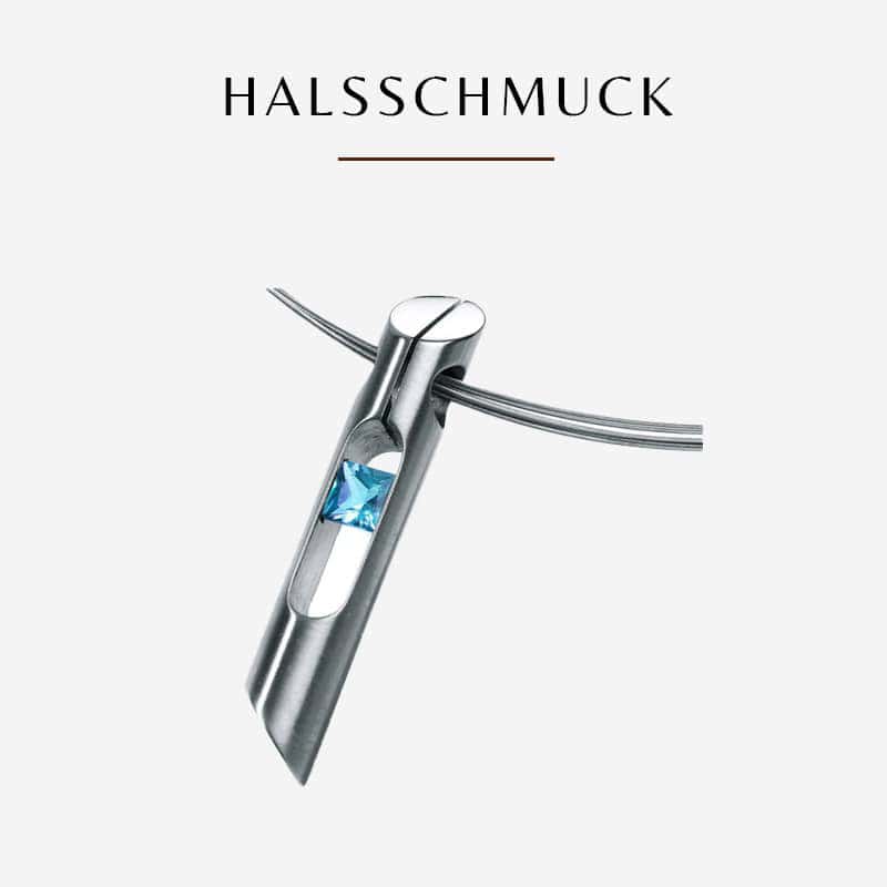 Ein schlichter, moderner Humphrey-Anhänger aus Silber in rechteckiger Form mit zwei ausgeschnittenen Abschnitten. Der untere Ausschnitt enthält einen kleinen, funkelnden blauen Edelstein. Der Anhänger ist an einer dünnen Silberkette befestigt. Über dem Anhänger steht in schwarzen Buchstaben das Wort „HALSSCHMUCK“.