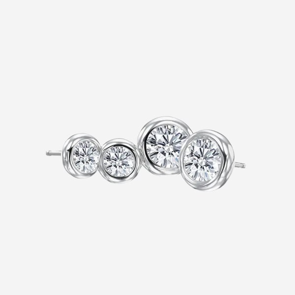 © Juwelier Wagner-Madler Ein Paar silberne Ohrstecker mit runden, klaren, facettierten Edelsteinen in einer Zargenfassung. Die Ohrringe sind unterschiedlich groß, mit einem großen und einem kleinen Edelstein pro Ohrring, die entlang des Ohrläppchens getragen werden sollen. Weitere Schmuckdetails finden Sie in unserem Schmucklexikon. Der Hintergrund ist weiß.