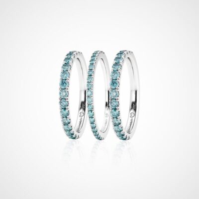 © Juwelier Wagner-Madler Drei Silberringe mit türkisfarbenen Edelsteinen, die an die im Schmucklexikon häufig gezeigten Designs erinnern, sind in einem durchgehenden Muster um jedes Band angeordnet und auf einem schlichten weißen Hintergrund dargestellt. Die Ringe sind aufrecht und eng aneinandergereiht angeordnet und zeigen ihr kompliziertes, funkelndes Design.