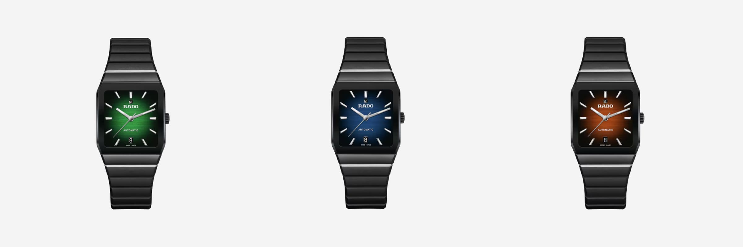 Drei rechteckige Armbanduhren mit schwarzen Metallarmbändern werden nebeneinander ausgestellt. Die Zifferblätter sind von links nach rechts grün, blau und braun. Jedes Ziffernblatt hat weiße Stundenmarkierungen, Zeiger, ein Markenlogo und eine „Automatic“-Beschriftung. Der Hintergrund ist weiß.