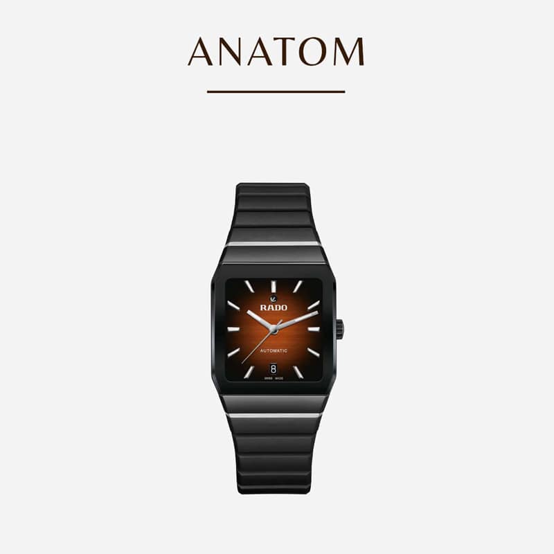Eine schwarze Armbanduhr mit rechteckigem Zifferblatt und einem braun-schwarzen Farbverlauf mit silbernen Stundenmarkierungen und Zeigern. Der Markenname ist auf dem Zifferblatt sichtbar, und die Uhr hat ein Metallarmband. Der Text darüber lautet „ANATOM“. Der Hintergrund ist weiß.