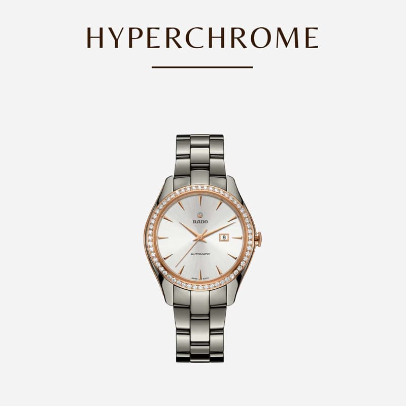 Eine elegante Rado Hyperchrome Uhr mit Metallarmband und rundem Zifferblatt. Die Uhr besticht durch Roségold-Akzente und eine Datumsanzeige vor minimalistischem grauem Hintergrund mit dem Schriftzug „HYPERCHROME“.