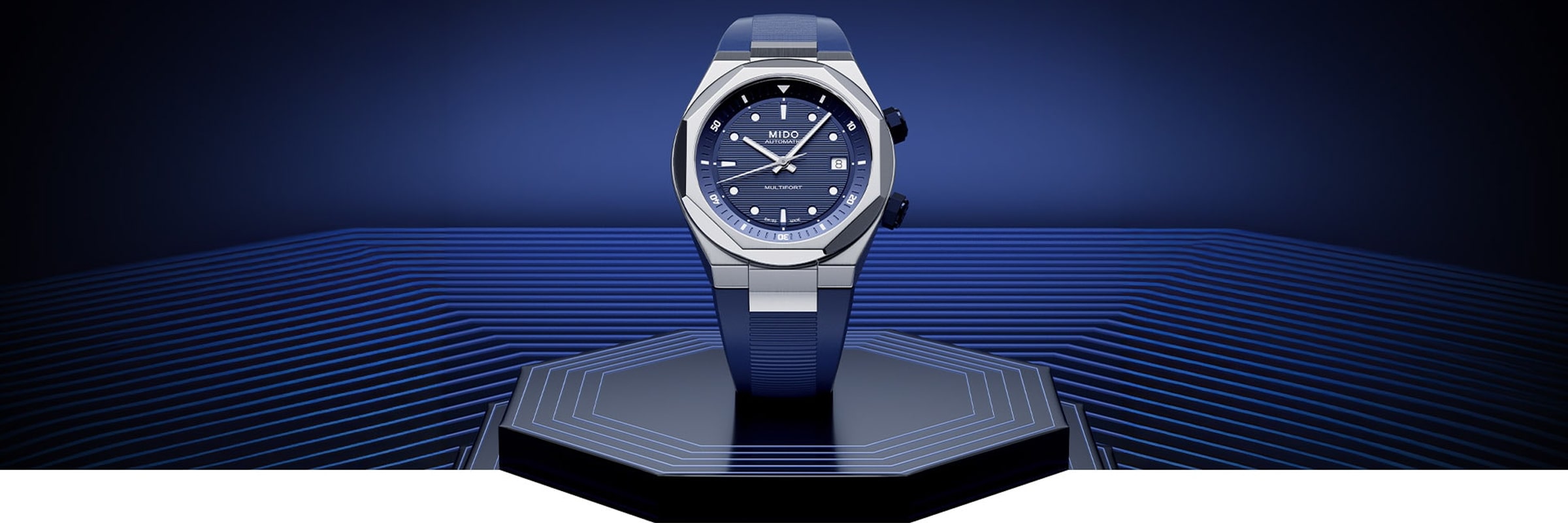 Eine elegante blaue Mido-Armbanduhr mit silbernem Gehäuse steht auf einer futuristischen, geometrischen blauen Plattform vor einem blauen Hintergrund mit horizontalen Linien und Farbverlauf.
