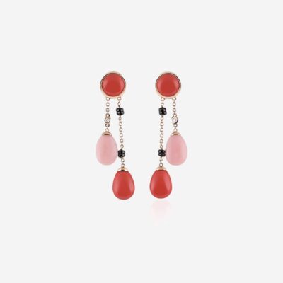Ein Paar elegante Tropfenohrringe mit roten, runden Ohrsteckern an der Oberseite. Jeder Ohrring hat eine Kette mit schwarzen Perlenakzenten, die mit einem tropfenförmigen roten Anhänger und einem rosa tropfenförmigen Anhänger verbunden sind, wodurch ein Kaskadeneffekt entsteht. Diese schmucklexikonwürdigen Ohrringe stehen auf einem weißen Hintergrund.