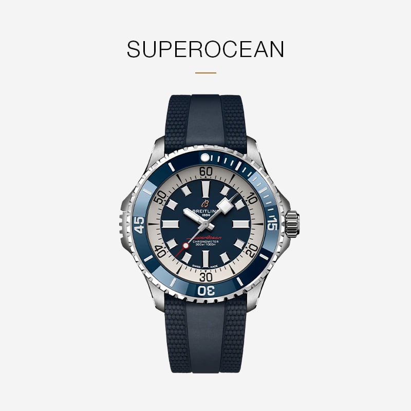 Eine Breitling Superocean Armbanduhr mit auffälliger blauer Lünette, blau-weißem Zifferblatt und blauem Strukturarmband wird auf einem hellen Hintergrund gezeigt.