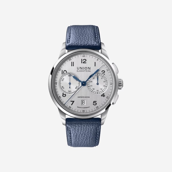 Eine silberne Chronographen-Armbanduhr mit weißem Zifferblatt, blauen Zeigern, schwarzen Ziffern, zwei Hilfszifferblättern, Datumsanzeige bei 6 Uhr und einem strukturierten blauen Lederband. Die Uhrenmarke "Union Glashütte" ist auf dem Zifferblatt sichtbar.