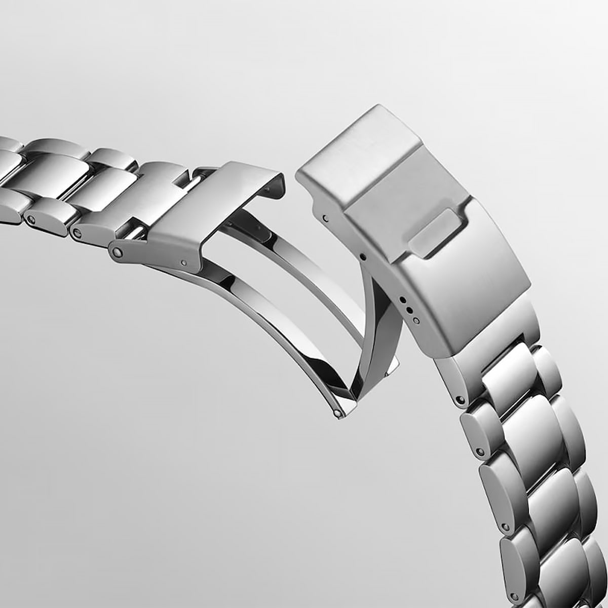 © Juwelier Wagner-Madler e.K. Eine Nahaufnahme eines Edelstahlarmbands mit Faltschließe, teilweise geöffnet, vor einem schlichten hellgrauen Hintergrund - eine ideale Detailaufnahme für jede Uhrenwerkstatt-Anzeige.