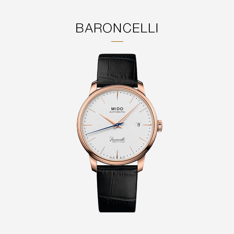 Die Mido Baroncelli Automatik-Armbanduhr mit weißem Zifferblatt, roségoldenem Gehäuse, schwarzem Lederarmband, blauem Sekundenzeiger, Datumsanzeige bei 3 Uhr und minimalistischen Stundenmarkierungen präsentiert sich elegant vor einem hellgrauen Hintergrund.