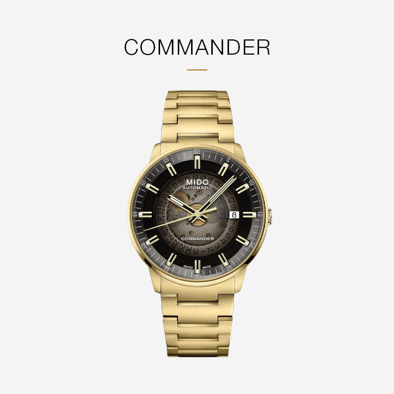 Goldene Armbanduhr mit schwarzem und goldenem Zifferblatt mit der Aufschrift "MIDO COMMANDER", goldenen Indexen und Zeigern an einem passenden goldenen Metallarmband. Dieser elegante Mido-Zeitmesser hebt sich von einem weißen Hintergrund ab.