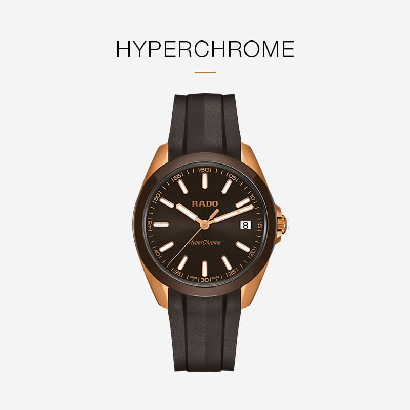 Eine Rado HyperChrome Armbanduhr mit schwarzem Zifferblatt, goldfarbenem Gehäuse, Datumsanzeige und schwarzem Armband wird auf einem weißen Hintergrund mit dem Text "HYPERCHROME" über der Rado Uhr gezeigt.