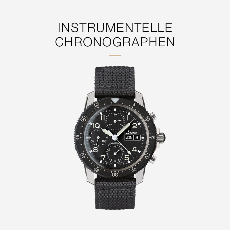 Eine schwarze Chronographen-Armbanduhr mit Stoffarmband von Sinn Spezialuhren ist auf einem schlichten Hintergrund abgebildet. Über der Uhr steht der Text "INSTRUMENTELLE CHRONOGRAPHEN.