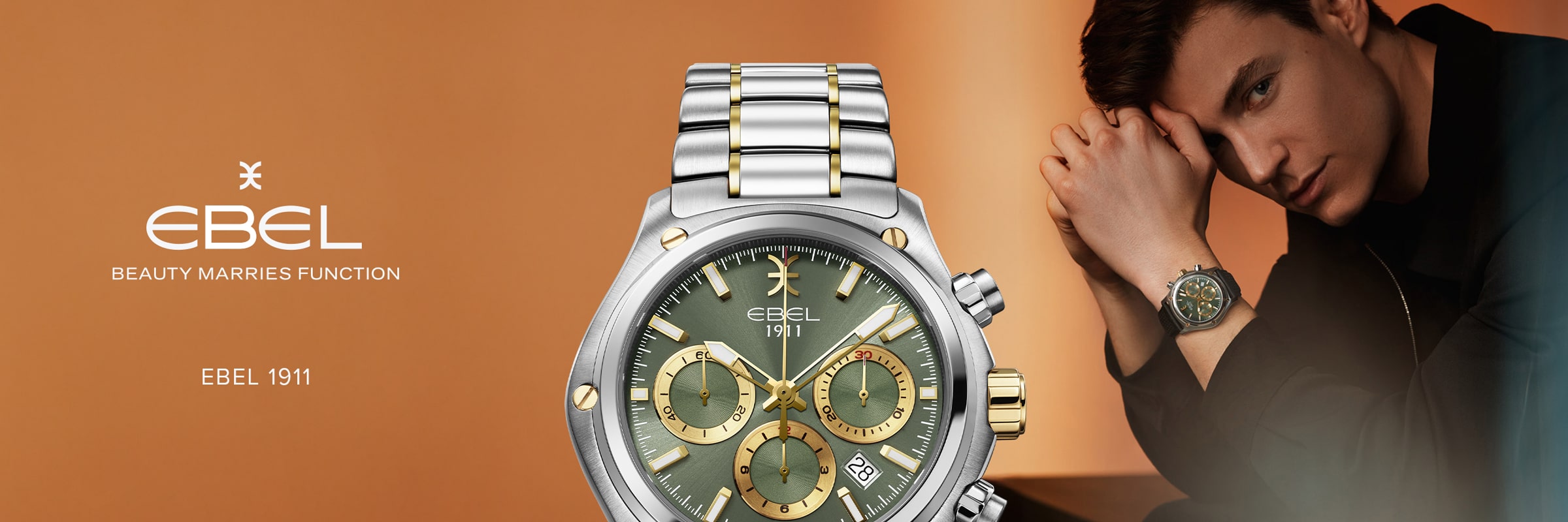 Ein Mann, der einen zweifarbigen Ebel 1911 Chronographen trägt, posiert mit erhobenem Handgelenk. Die Nahaufnahme hebt das grüne Zifferblatt mit goldenen Akzenten vor einem warmen braunen Hintergrund hervor, mit dem EBEL 1911 Logo und Slogan auf der linken Seite.
