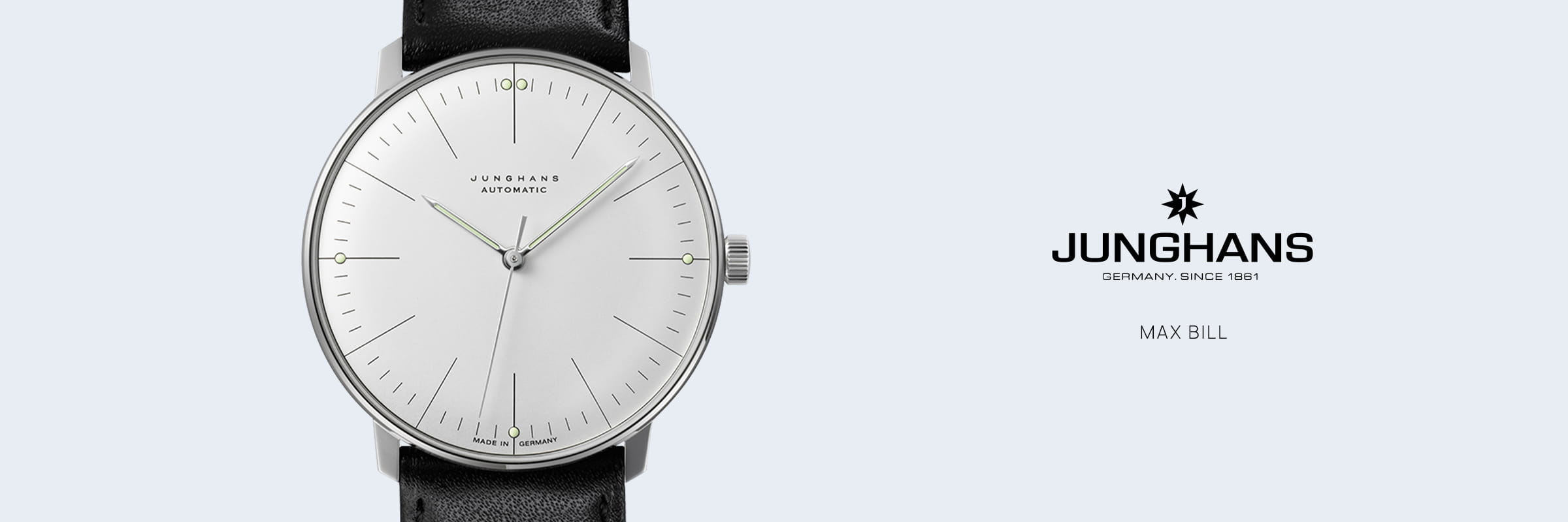 Abgebildet ist eine Junghans Max Bill Armbanduhr mit weißem Zifferblatt, schmalen Stundenmarkierungen und schwarzem Lederarmband. Auf der rechten Seite sind das Junghans-Logo und "GERMANY. SINCE 1861. MAX BILL" heben dieses ikonische Bauhaus-Design hervor.