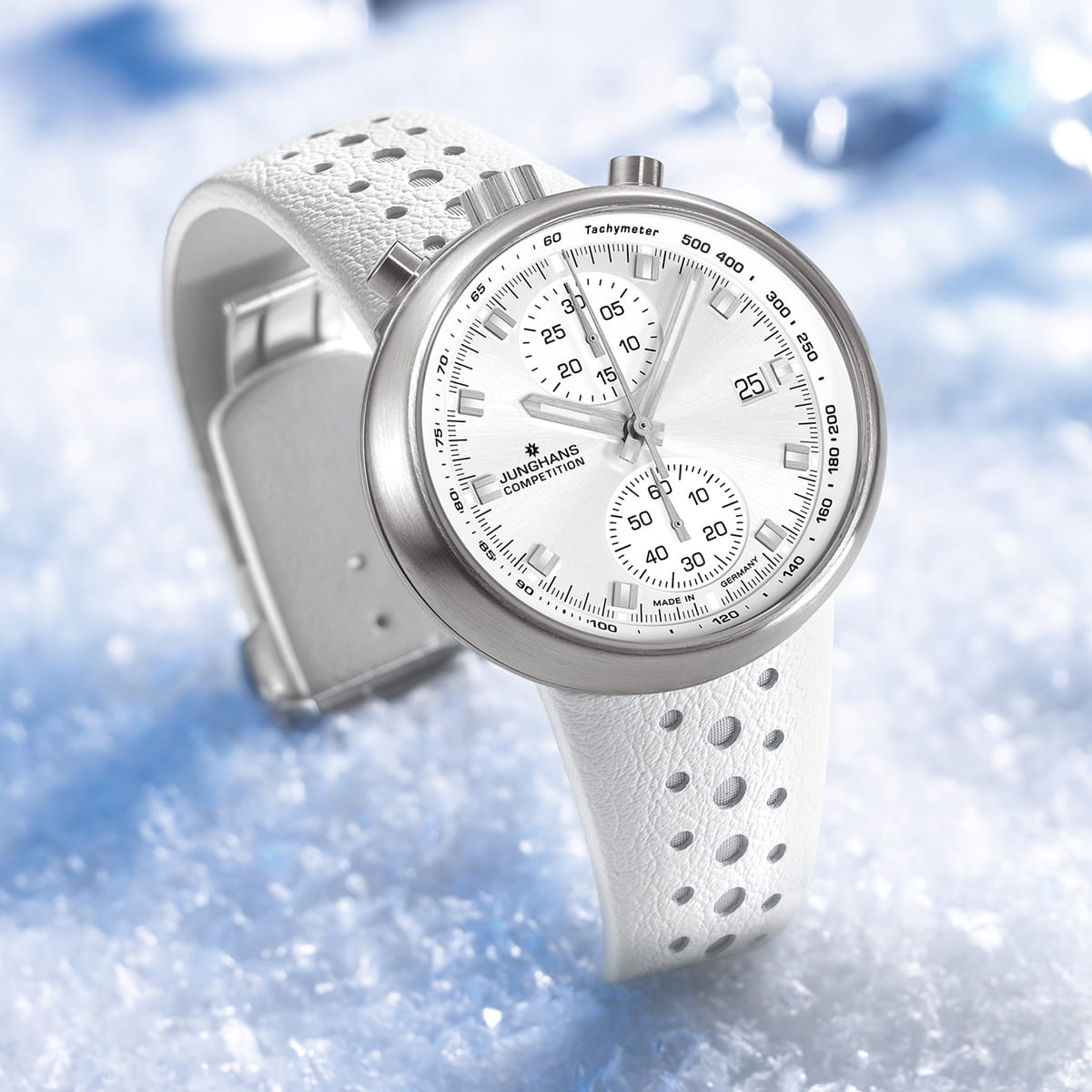 Eine weiße Junghans Sport-Chronographenuhr mit perforiertem Armband wird auf einem Eisbett präsentiert, das die silberne Lünette, das weiße Zifferblatt und das dynamische sportliche Design hervorhebt.