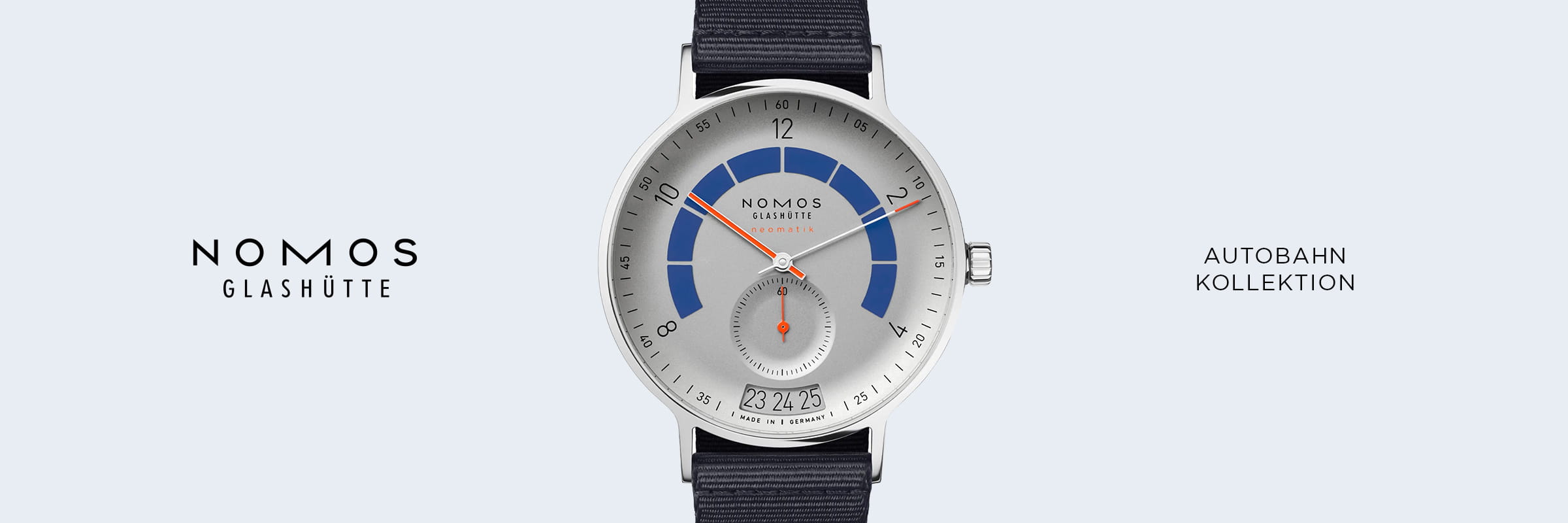 Eine NOMOS-Autobahnuhr Glashütte mit silbernem Gehäuse, blau-grauem Zifferblatt, schwarzem Armband und Datumsanzeige vor hellgrauem Hintergrund mit Marken- und Kollektionsnamen auf beiden Seiten.