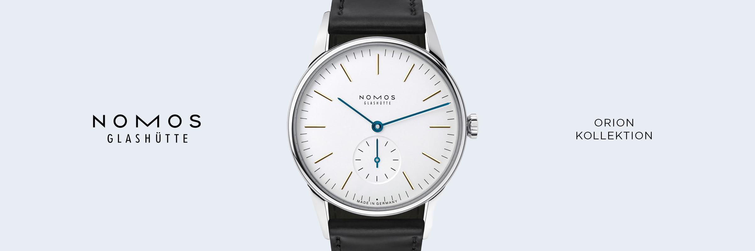 Eine minimalistische NOMOS Orion Glashütte Uhr mit weißem Zifferblatt, goldenen Indexen, blauen Zeigern und schwarzem Lederarmband ist auf hellgrauem Grund zentriert. Auf beiden Seiten stehen "NOMOS GLASHÜTTE" und "ORION KOLLEKTION".