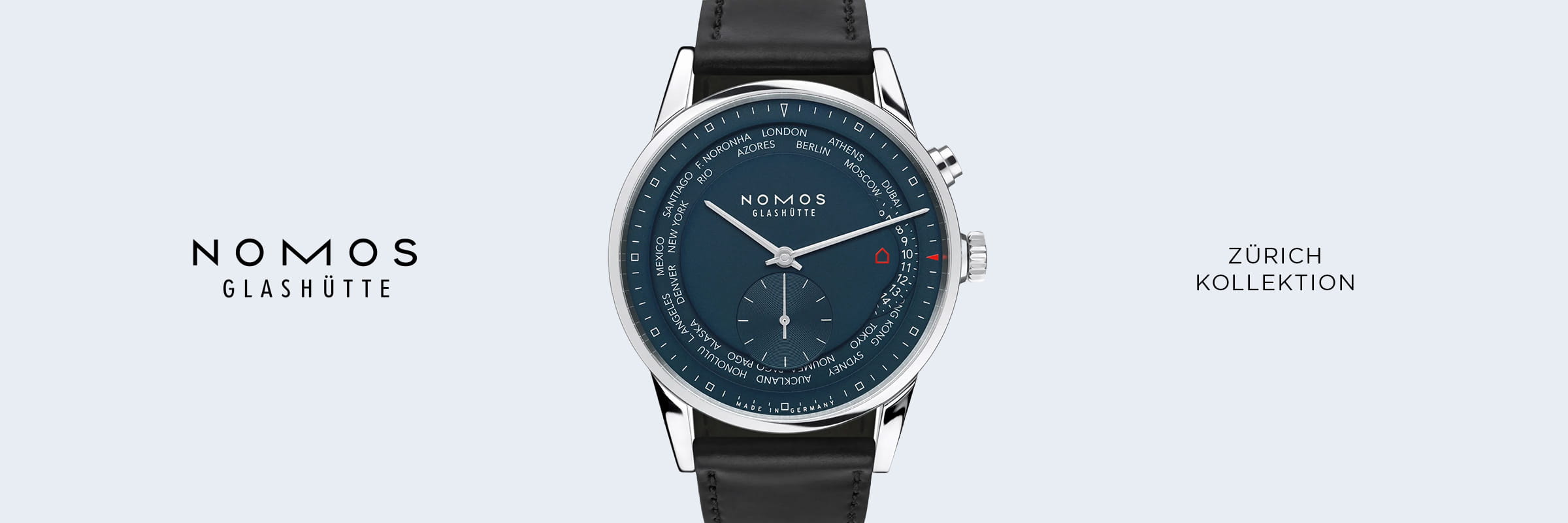 Eine Armbanduhr der Kollektion NOMOS Zürich Glashütte mit blauem Zifferblatt, silbernem Gehäuse und schwarzem Lederarmband ist auf hellem Grund zentriert und zeigt am Rand die Städte der Weltzeit an.