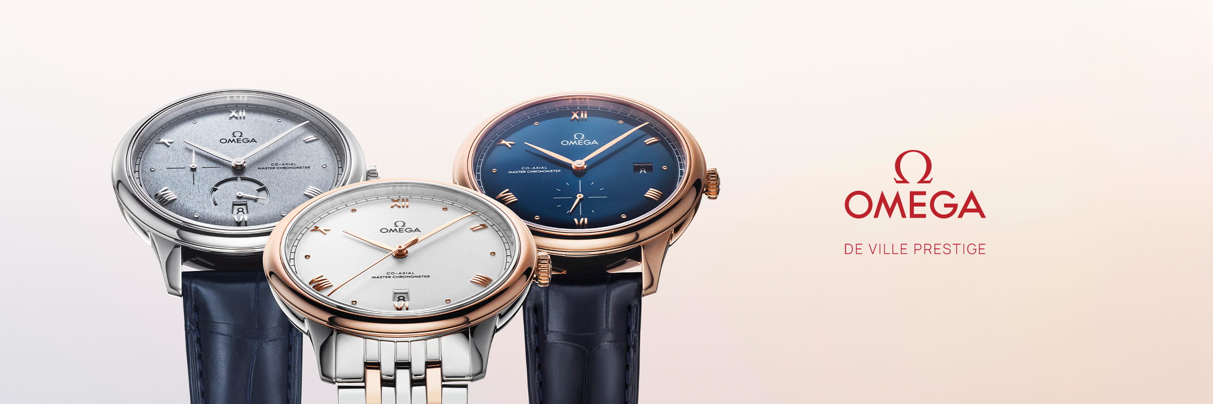 OMEGA © 2026 Drei OMEGA Prestige De Ville Armbanduhren sind abgebildet: zwei mit silbernen Zifferblättern und eine mit blauem Zifferblatt. Das OMEGA-Logo und der Text "De Ville Prestige" erscheinen auf der rechten Seite vor einem hellen Hintergrund.