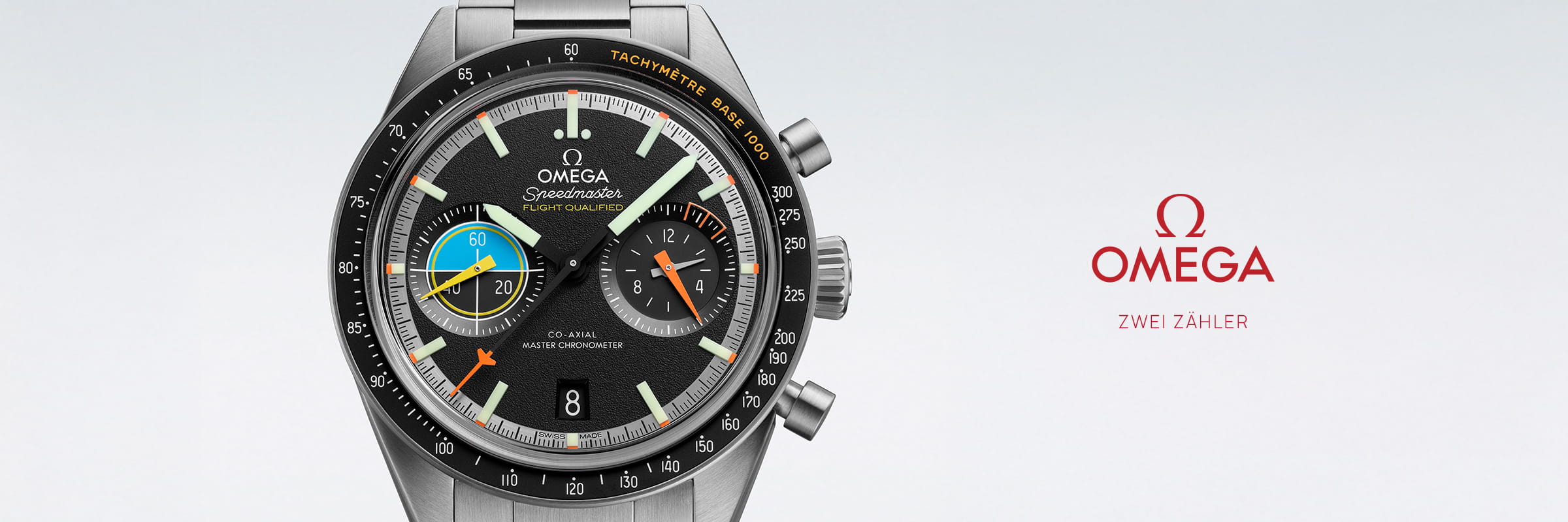 OMEGA © 2026 Eine Nahaufnahme einer Omega Speedmaster-Armbanduhr mit mehreren Ziffernblättern und bunten Details auf dem Zifferblatt. Rechts ist das rote OMEGA-Logo und der deutsche Schriftzug "OMEGA Zwei Zähler" auf hellem Hintergrund zu sehen.