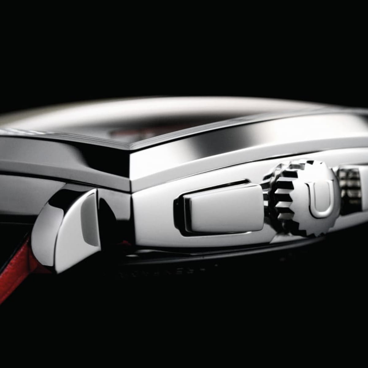 Nahaufnahme der Seite einer Union Glashütte Averin Luxusarmbanduhr, die die metallene Krone, die Knöpfe und einen Teil des Gehäuses vor einem schwarzen Hintergrund zeigt. Die Details unterstreichen die polierte und präzise Handwerkskunst der Uhr.